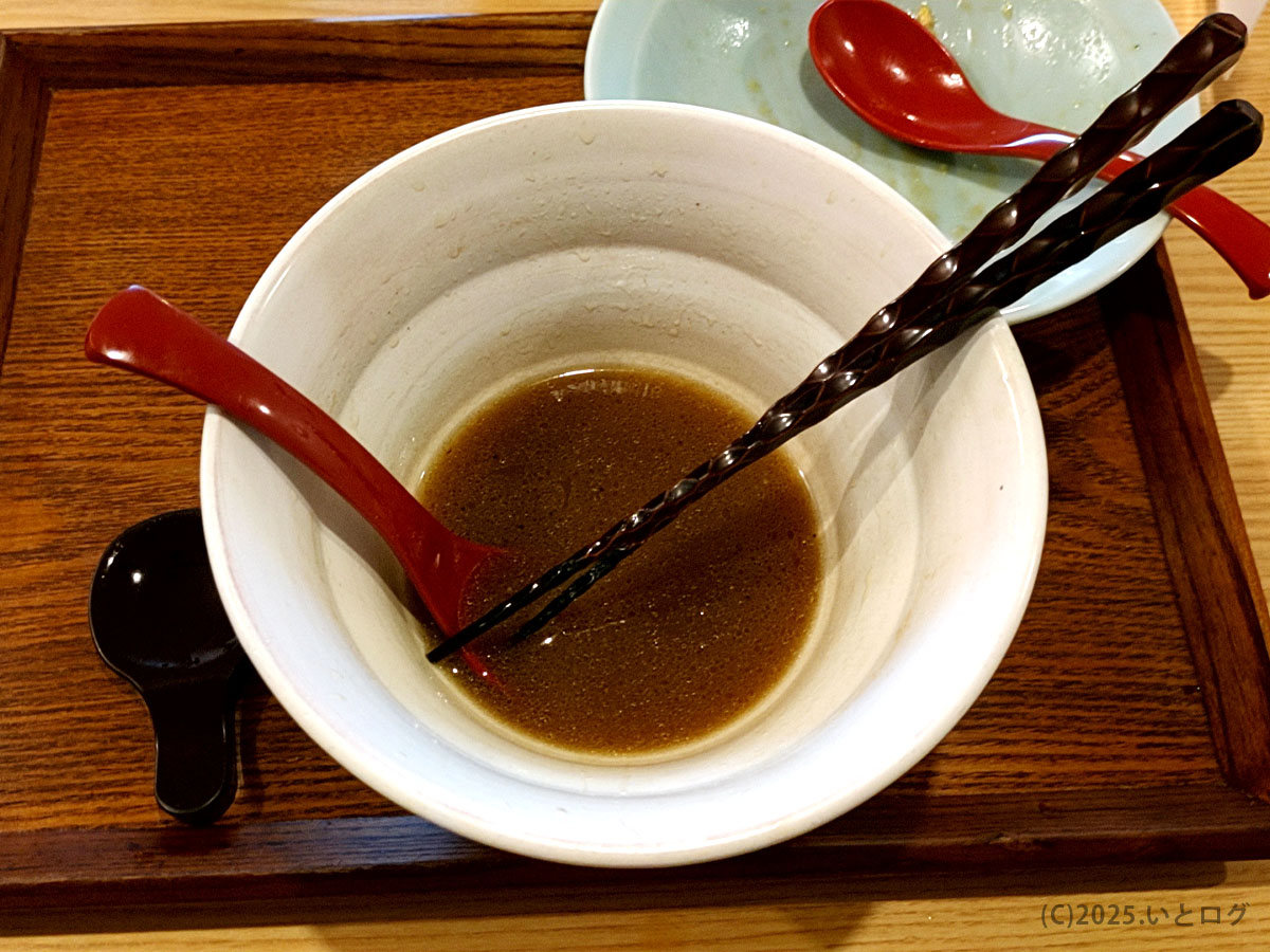 『麦右衛門 メニュー』の看板商品を完食し、香りだけが残る白い丼。赤いレンゲとらせん柄の箸が余韻を物語る。