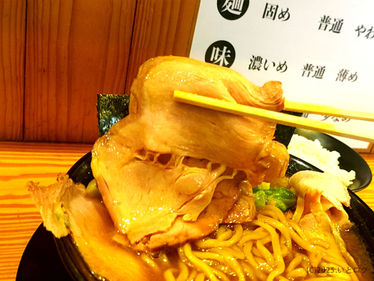 伯耆家のラーメン丼を箸で持ち上げたチャーシューの迫力ショット。SNSやTwitterでも人気を集めるボリューム感。