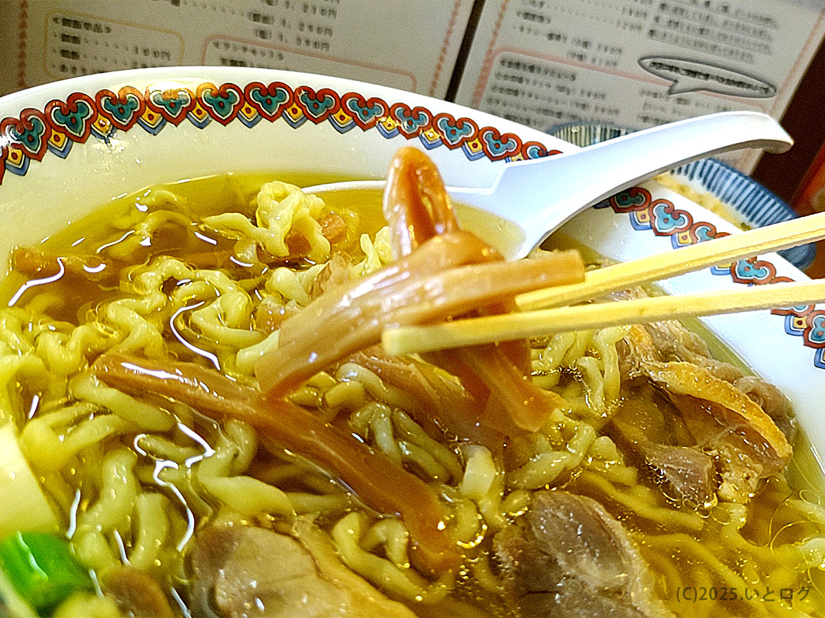 仙台中華そば 嘉一のメンマを箸でつまむ瞬間。醤油の香りがふわりと立ち、スープとの相性も抜群。嘉一秋保店でも人気の具材で、ラーメン通から高い支持を得ている。