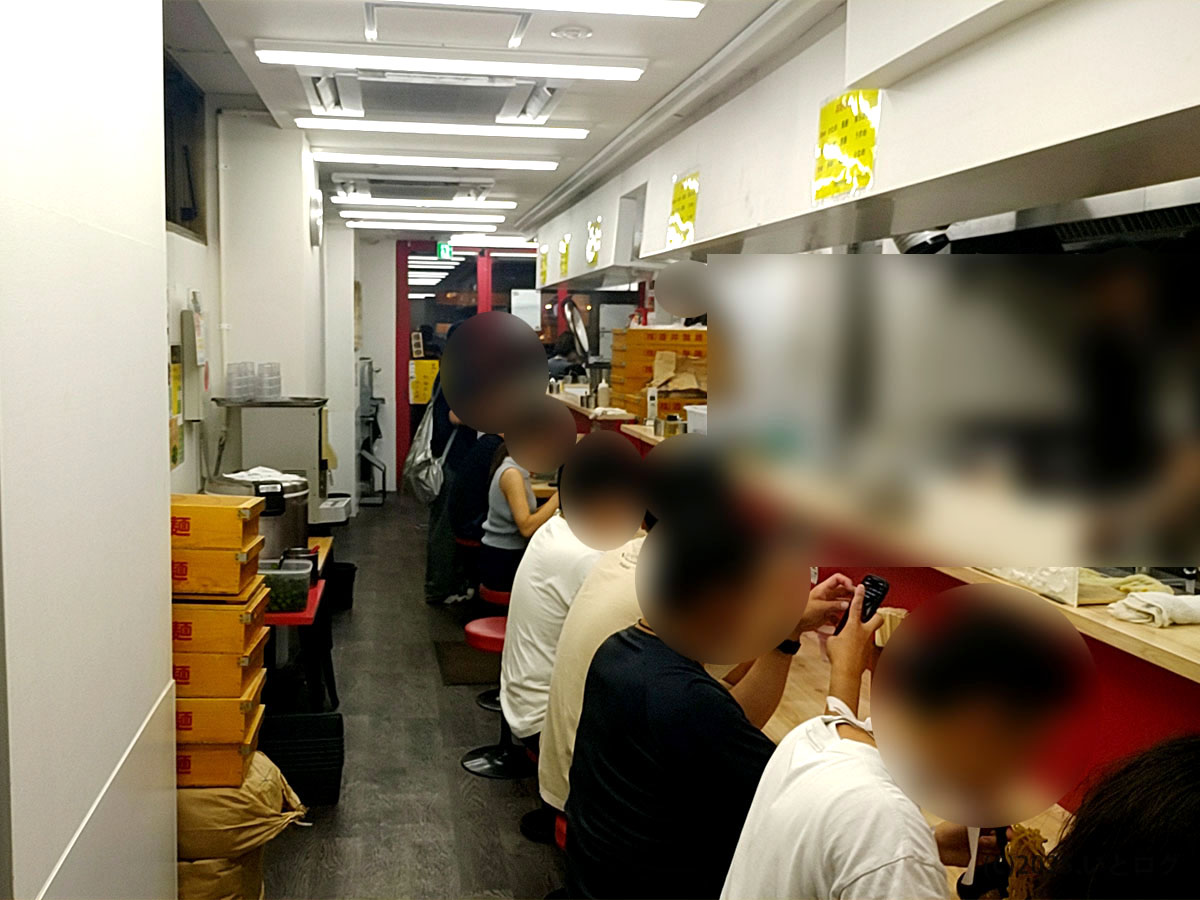 武道家 口(くにがまえ)国分寺の店内カウンター席。国分寺駅近くの人気家系ラーメン店らしく、行列後の客で賑わう様子。濃厚家系を求める人が多く、武道家系統ならではの活気が感じられる。