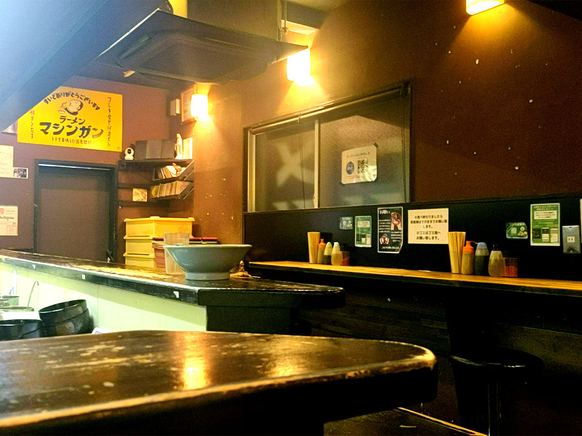 秋田市にあるラーメンマシンガンの店内カウンター。ラーメンマシンガングループらしいシンプルな内装