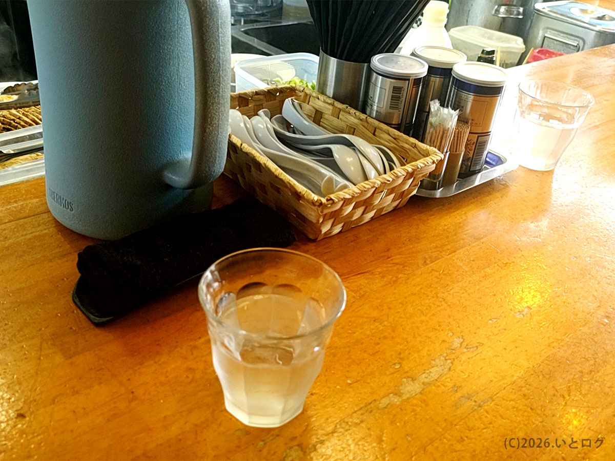 麺饗 松韻の卓上調味料とお冷。シンプルなセッティングが松韻らしい由利本荘ラーメン店のカウンター