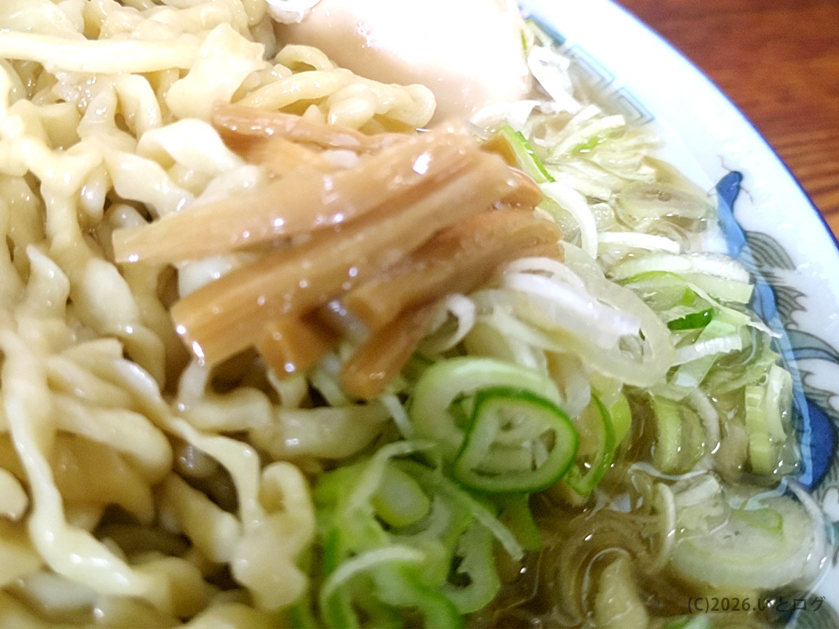 ケンちゃんラーメン 本店のラーメンの麺と具材のアップ。太めの縮れ麺と刻みネギが確認できる