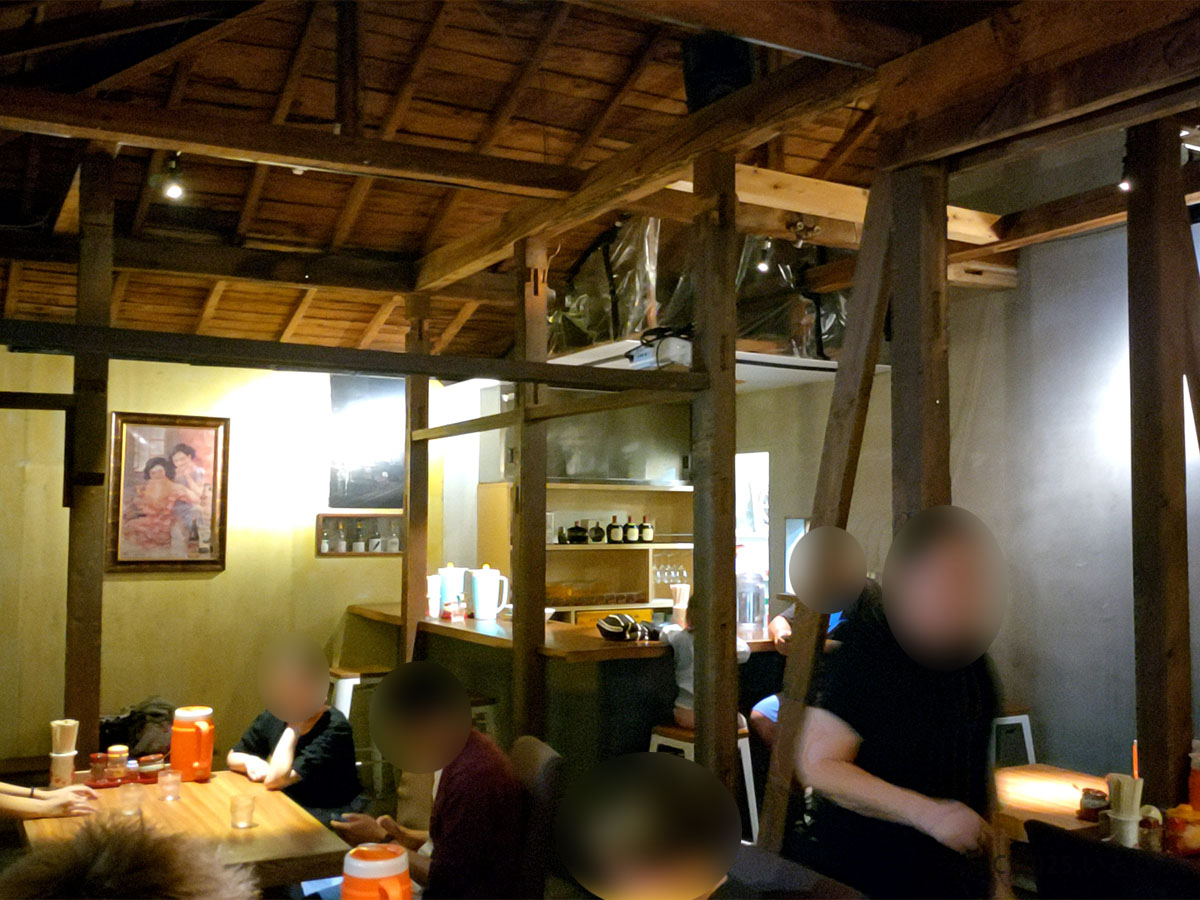 「中華蕎麦よるのふじの店内。梁の見える高い天井と木の柱が印象的。夜の富士山エリアらしい古民家風の温かい空間で、ラーメンを楽しむ客たち。」
