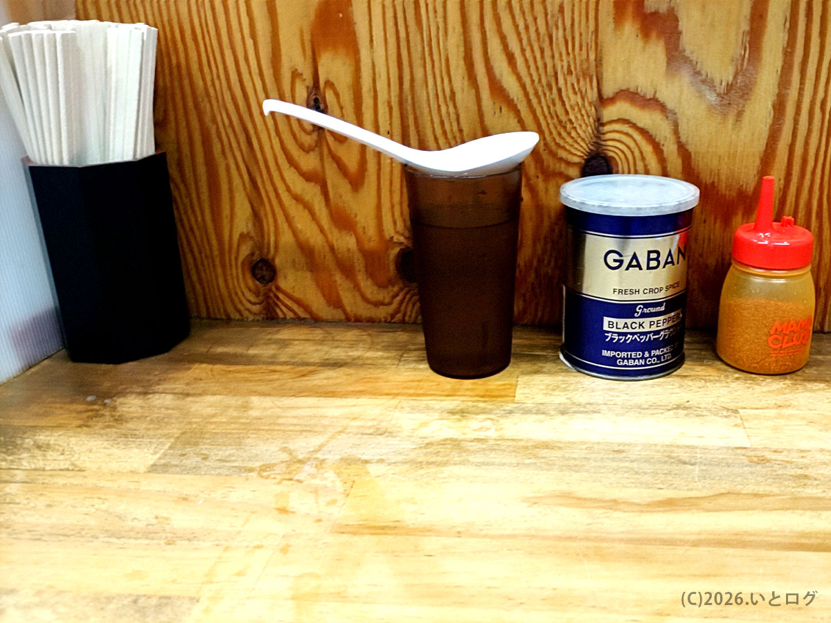 ラーメン二郎 前橋千代田町店の卓上調味料。GABANの黒胡椒や一味が並ぶカウンターの様子