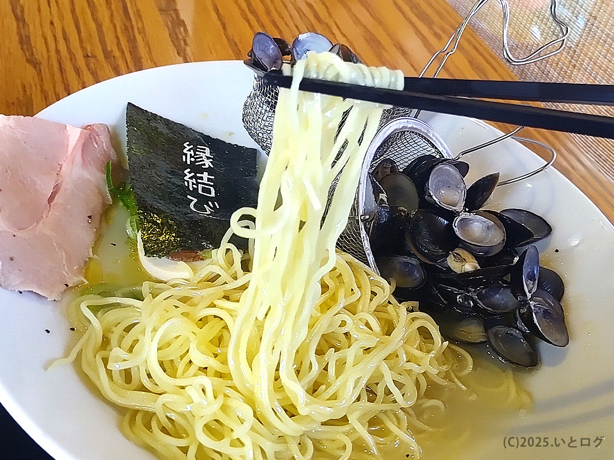 かみあり製麺 出雲の名物しじみ塩ラーメンを箸で持ち上げた麺リフトの様子。スープにしじみの旨みが凝縮され、縁結びの海苔も添えられている。