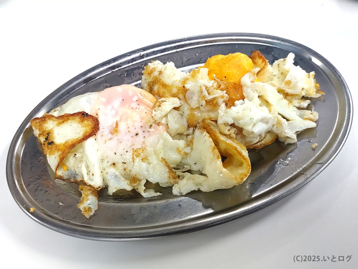 仙台の『もつ焼き 丸昌』で出される素朴な目玉焼き。香ばしく焼けた白身と、とろりとした黄身が銀皿に盛られた、酒のつまみにぴったりの一皿