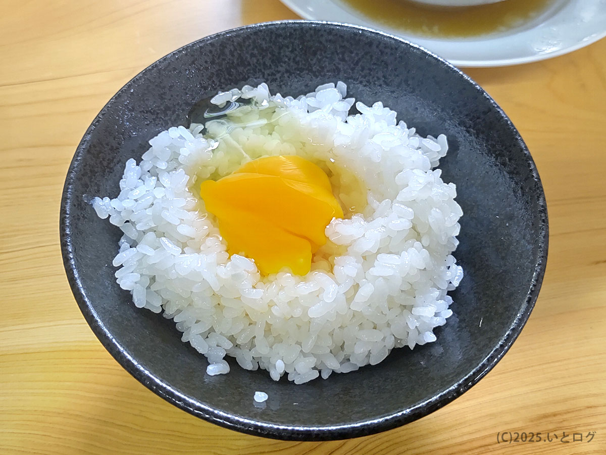 あざみで提供されるご飯に生卵をのせた一品。中華そばと合わせて味わう人も多く、富山県のラーメン店らしい素朴な組み合わせ。