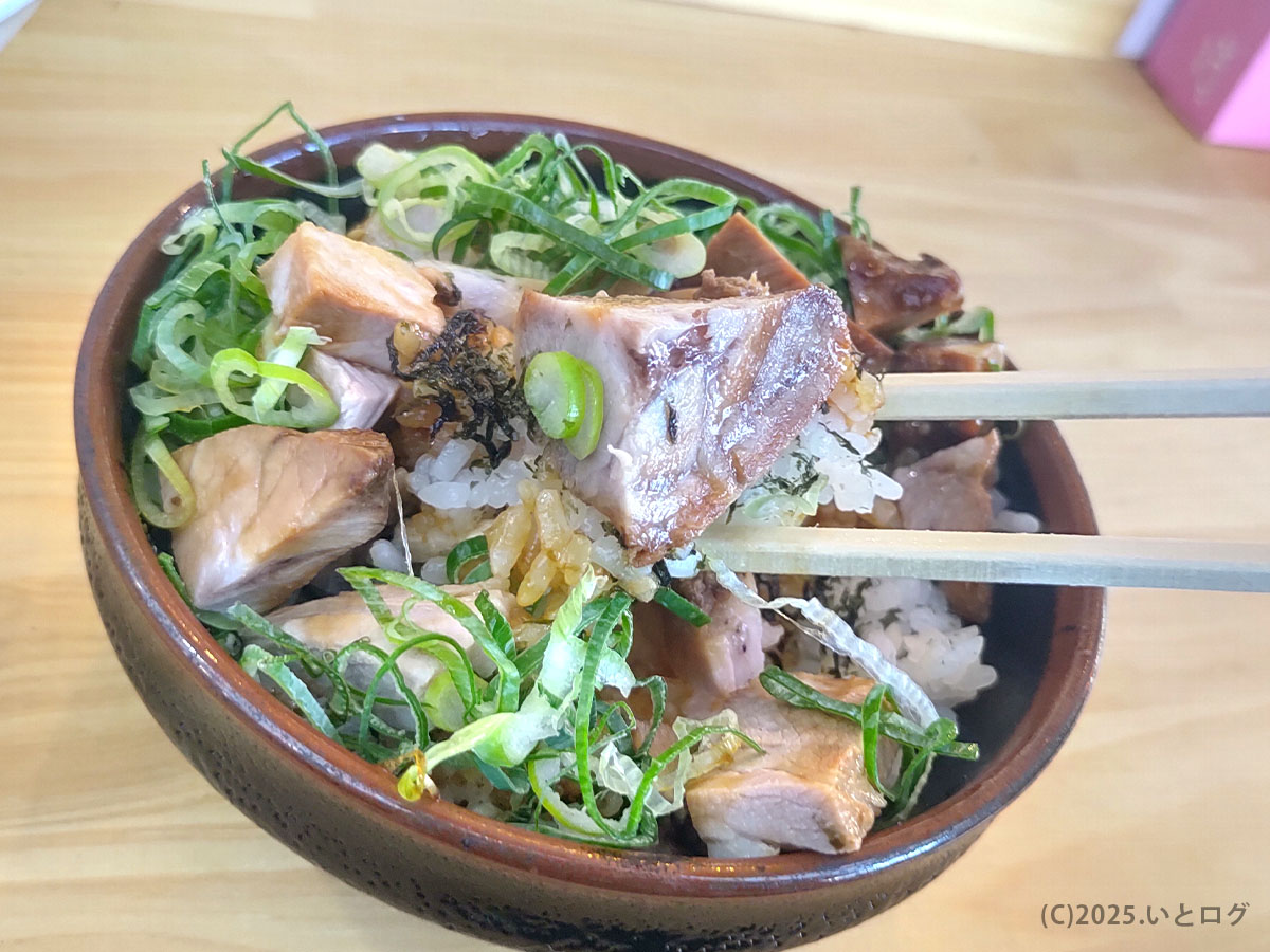 ときどき思い出したくなる肉の旨み—箸で持ち上げた角切りチャーシューと香ばしいご飯のアップ。