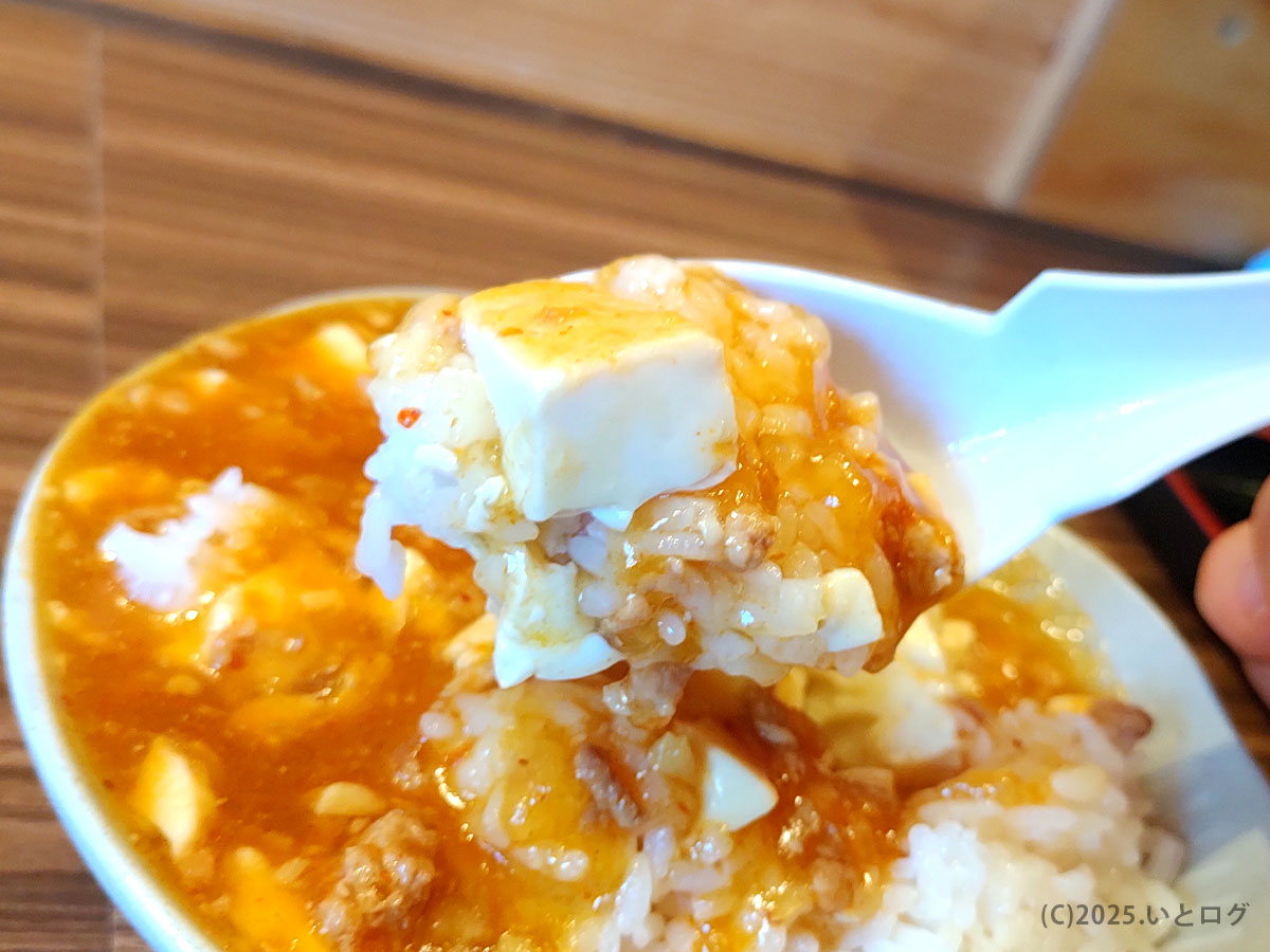 中華そば わだ屋甲府昭和分店の「本日のご飯もの」麻婆丼。豆腐と甘辛あんがご飯に絡むレンゲショット