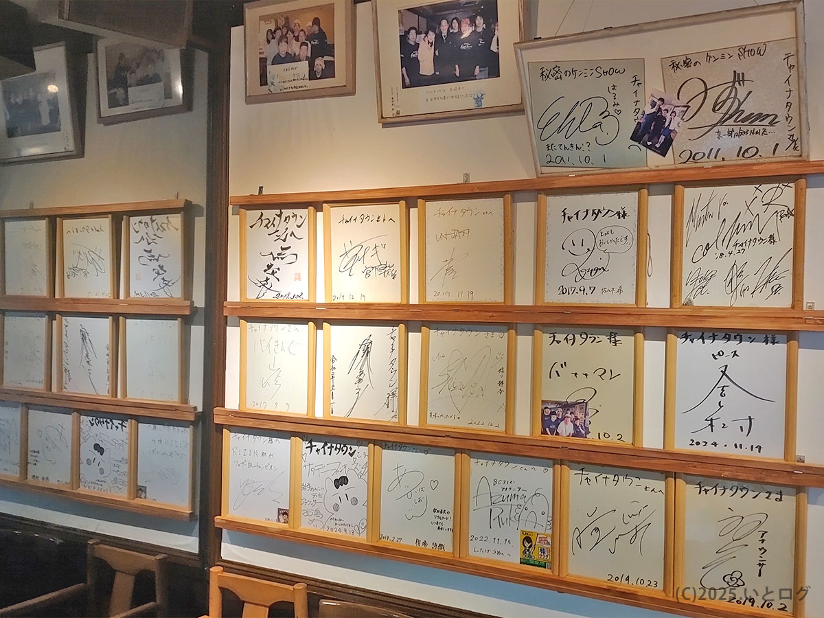 秋田市にあるラーメンショップ チャイナタウンの店内壁に飾られた色紙やサインが並ぶ様子