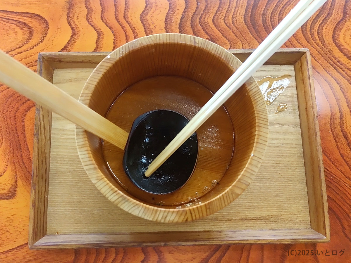 木桶にスープの余韻だけが残る山梨源水ラーメン、完食後のレンゲと箸が静かに佇む