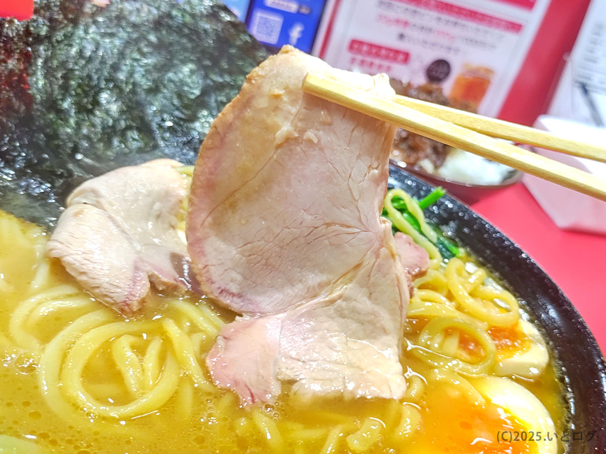 王道家直伝の家系ラーメン青森野呂家、厚切りチャーシューを箸で持ち上げた様子