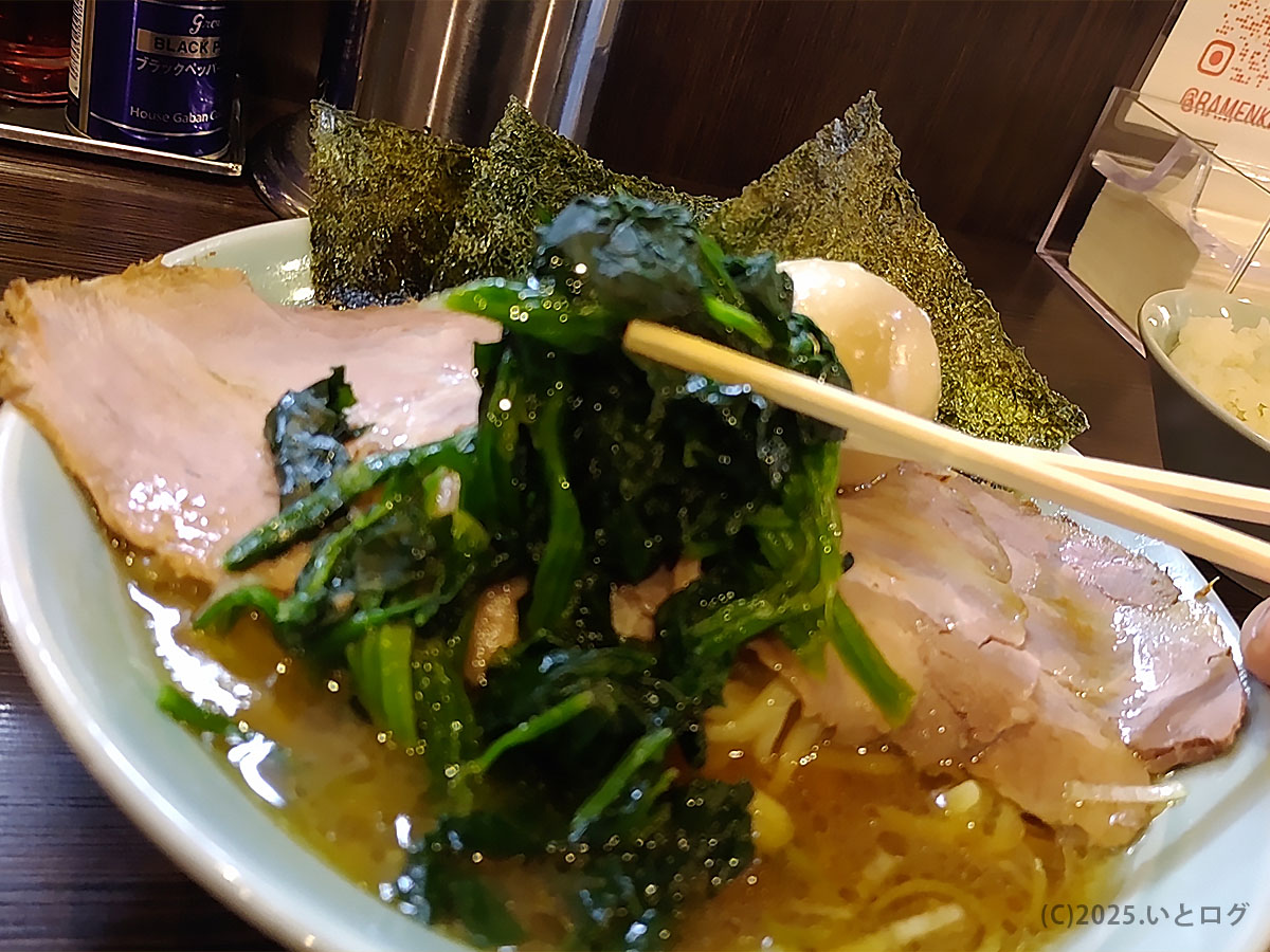 チャーシュー麺の上でほうれん草をリフトアップ。濃厚醤油スープが輝き、横浜家系の系譜=雷家 家系図を感じさせる一枚。