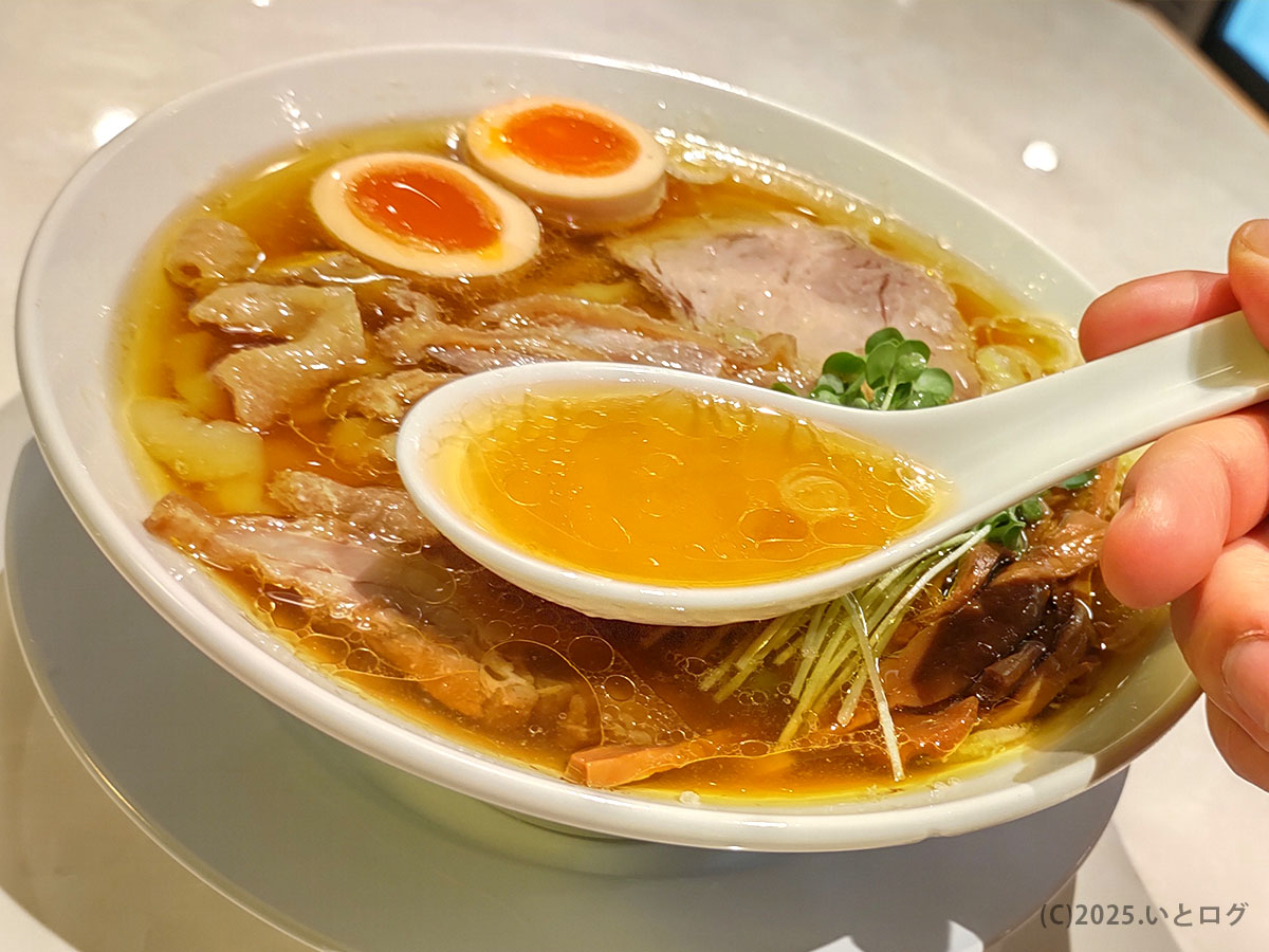 レンゲにすくった黄金色の鶏油スープ。香りとコクが一口で広がり、静岡インター店ならではの深い味わい。