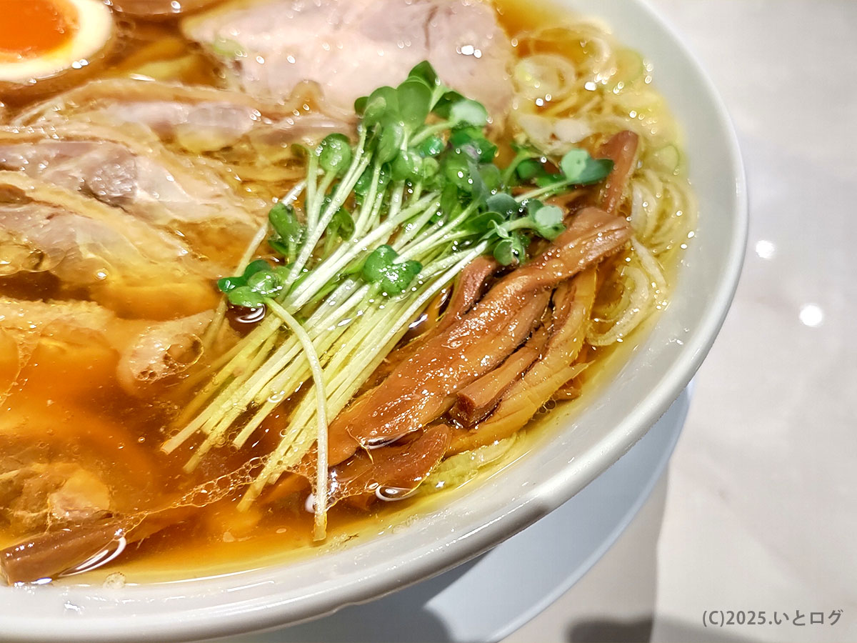 シャキッとしたカイワレと味染みメンマが彩る丼の端。親鶏チャーシューの旨味を引き立てる名脇役たち。