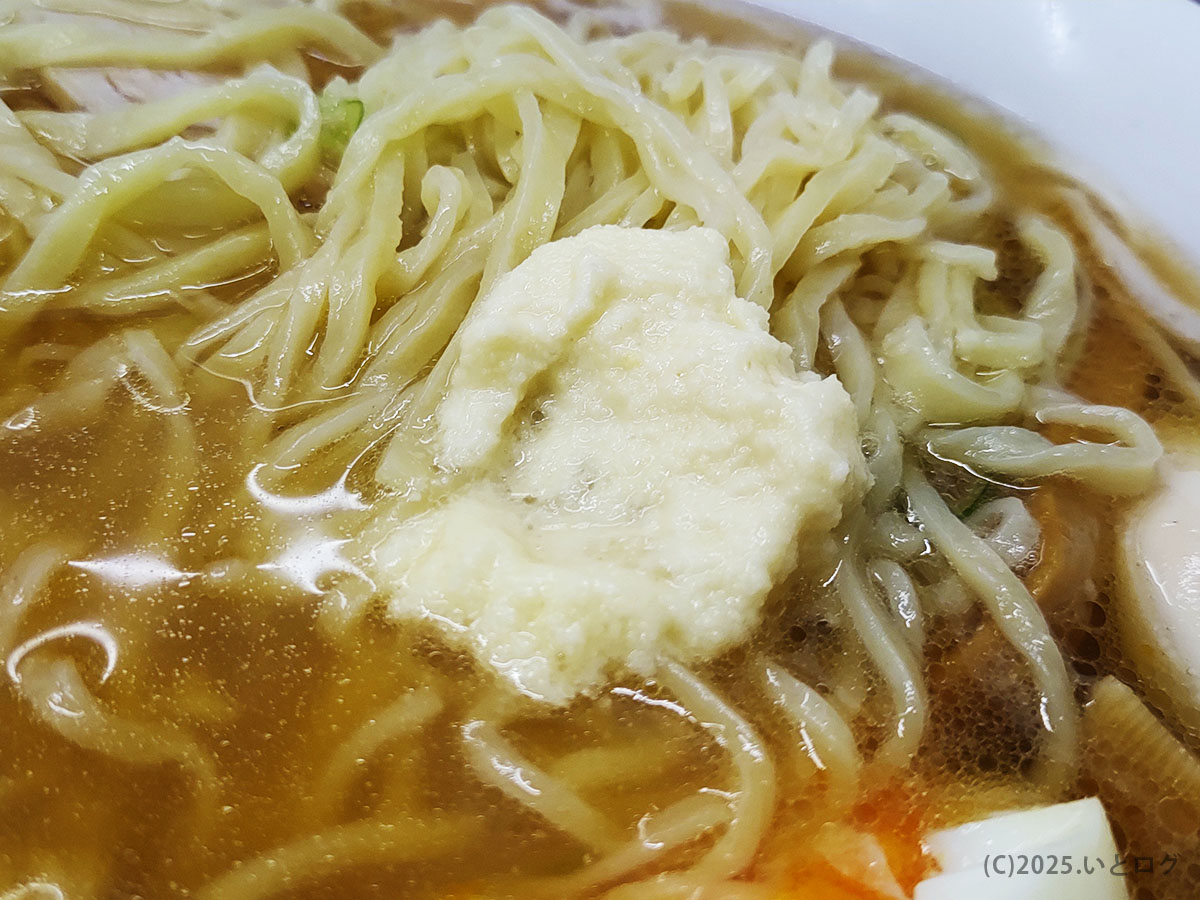 縮れた青竹手打ち麺の上にふわりとのせられた白おろし(おろしニンニク)。スープと絡んで風味を変化させる