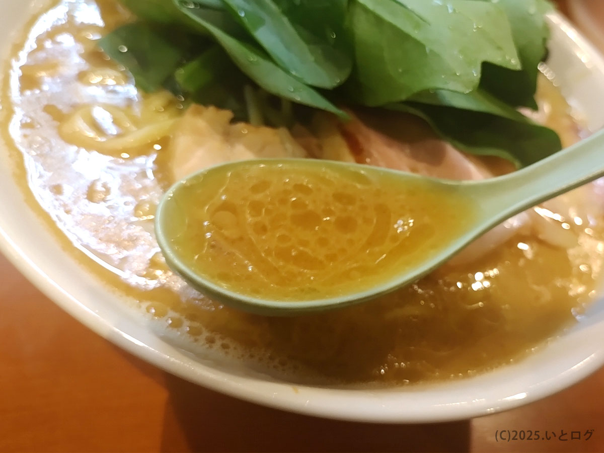 黄金色の鶏油が輝くレンゲ一杯の豚骨醤油スープ。家系ラーメンとは何かを語る濃厚なコク。