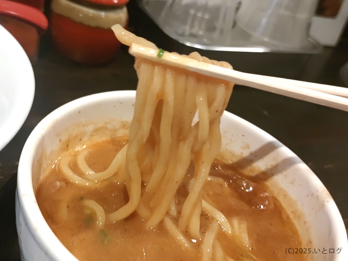 もっちり極太麺をつけ汁にくぐらせるシーン。口当たりを想像させる迫力あるクローズアップで〈蔵木 店舗〉の臨場感を演出。