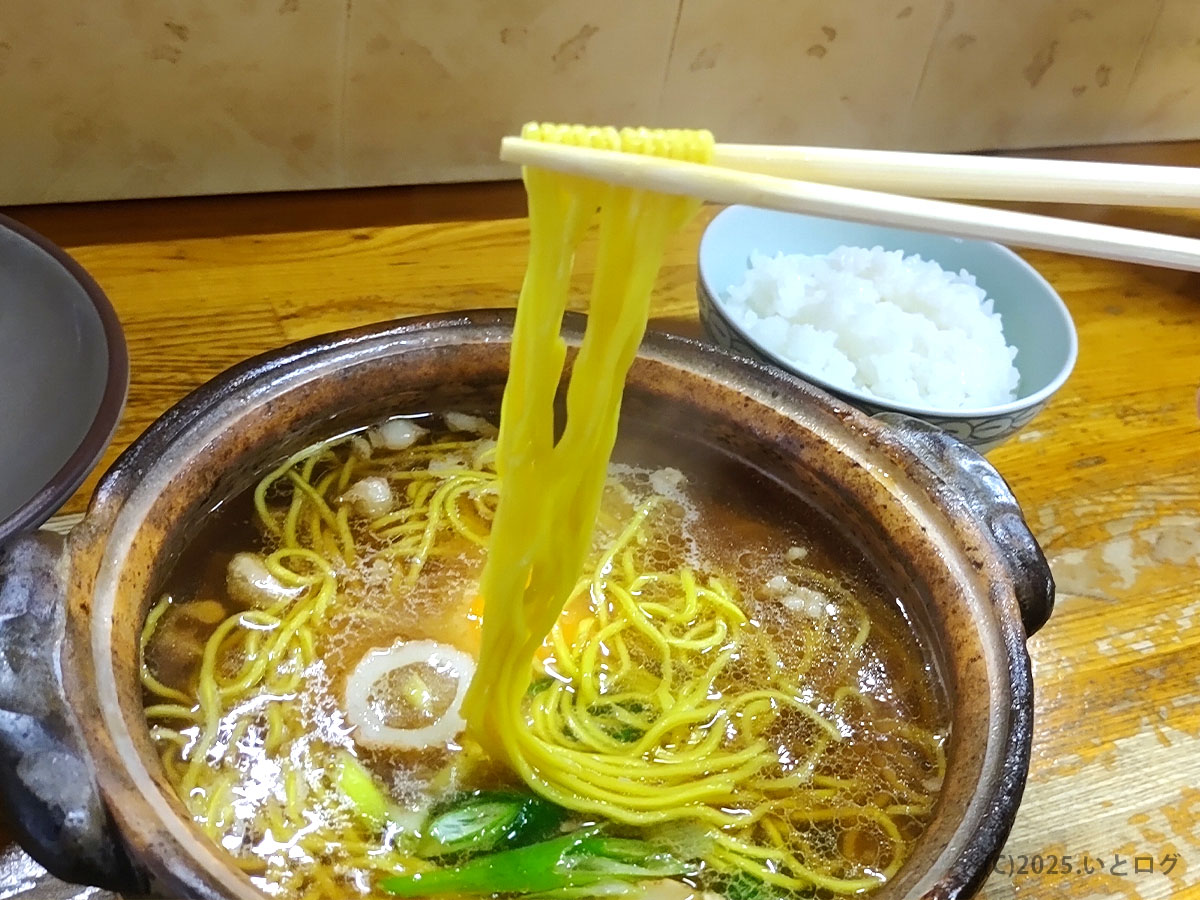 湯気を上げる細麺を箸で持ち上げる瞬間。卵黄と絡む麺は橋本食堂 鍋焼きラーメン 作り方の醍醐味。