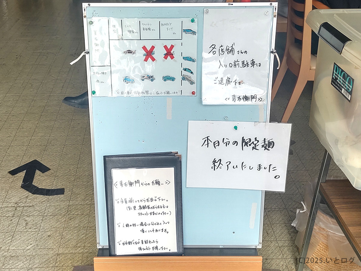 中華そば麦右衛門 駐車場案内ボード(いわゆる麦右衛門 駐車場ガイド)。「各店舗入口前駐車禁止」の図解と「本日の麦右衛門 限定麺 終了」の張り紙が並ぶ。