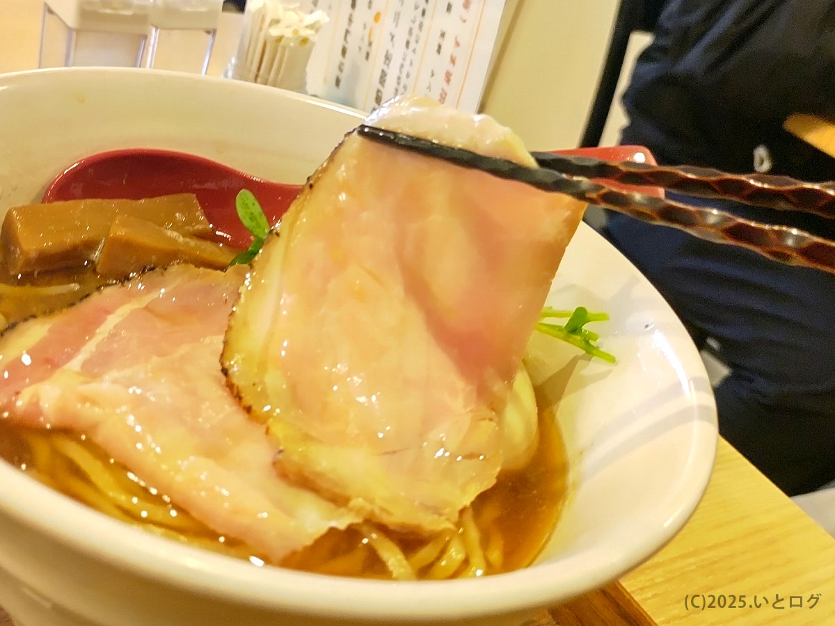 麦衛門 メニューの象徴・大判レアチャーシューを箸でリフトアップ。ピンク色の肉がスープ越しに艶めく。