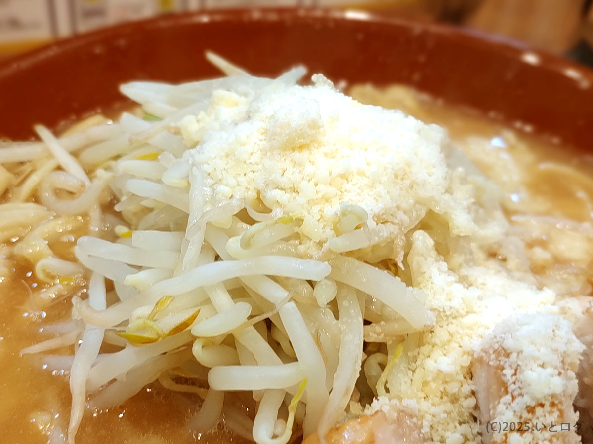 山盛りもやしの頂に粉チーズが雪化粧。「豚山 静岡 コール」で野菜マシ+粉チーを頼むと現れる“あれ”を間近に捉えたアップ。