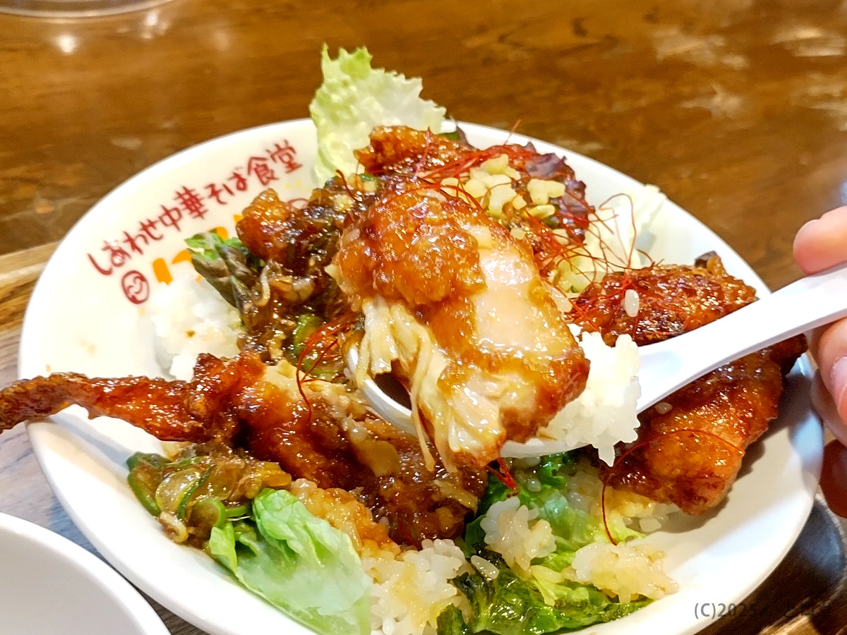 スプーンで頬張る香味から揚げ丼のアップ。甘辛タレが染みた鶏肉とご飯が一体になり、満足度抜群。