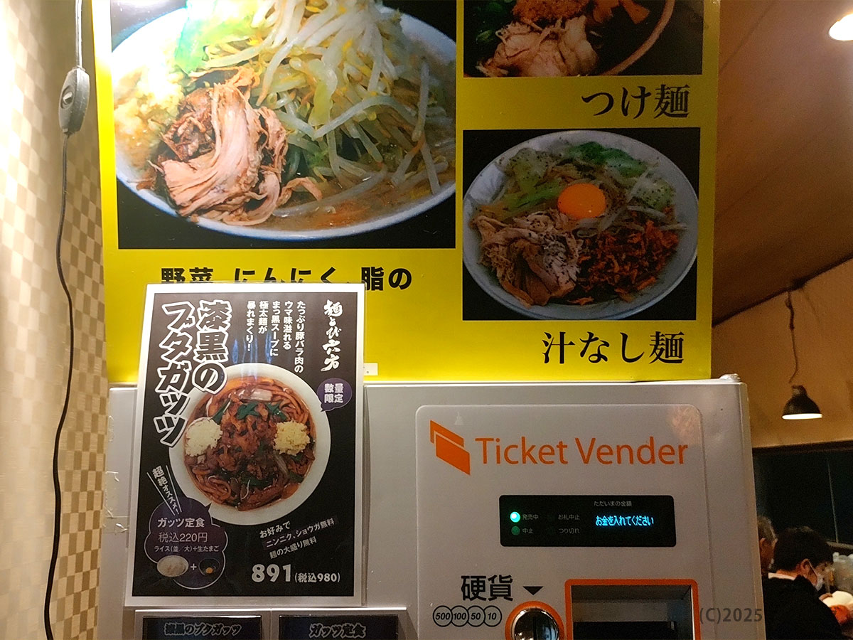 麺とび六方 茅野店の食券機「Ticket Vender」と壁一面のメニュー写真。つけ麺・汁なし麺や「漆黒のブタカツ」POPが目立ち、頼み方がひと目で分かる店内掲示。