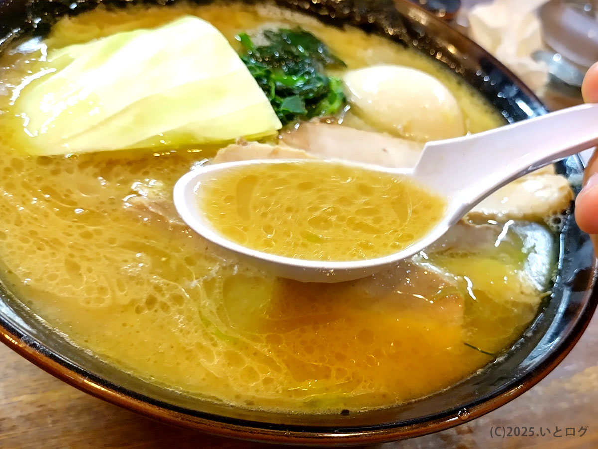 濃厚豚骨醤油スープをレンゲですくう瞬間。キャベツが映えるらあめん寸八 松本の看板ラーメン。