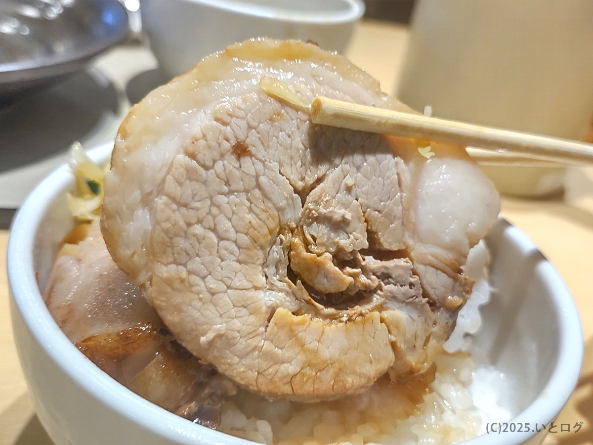 肉厚バラチャーシューをリフト! 尚念 安曇野店でも評判の柔らかさと迫力が伝わるショット。