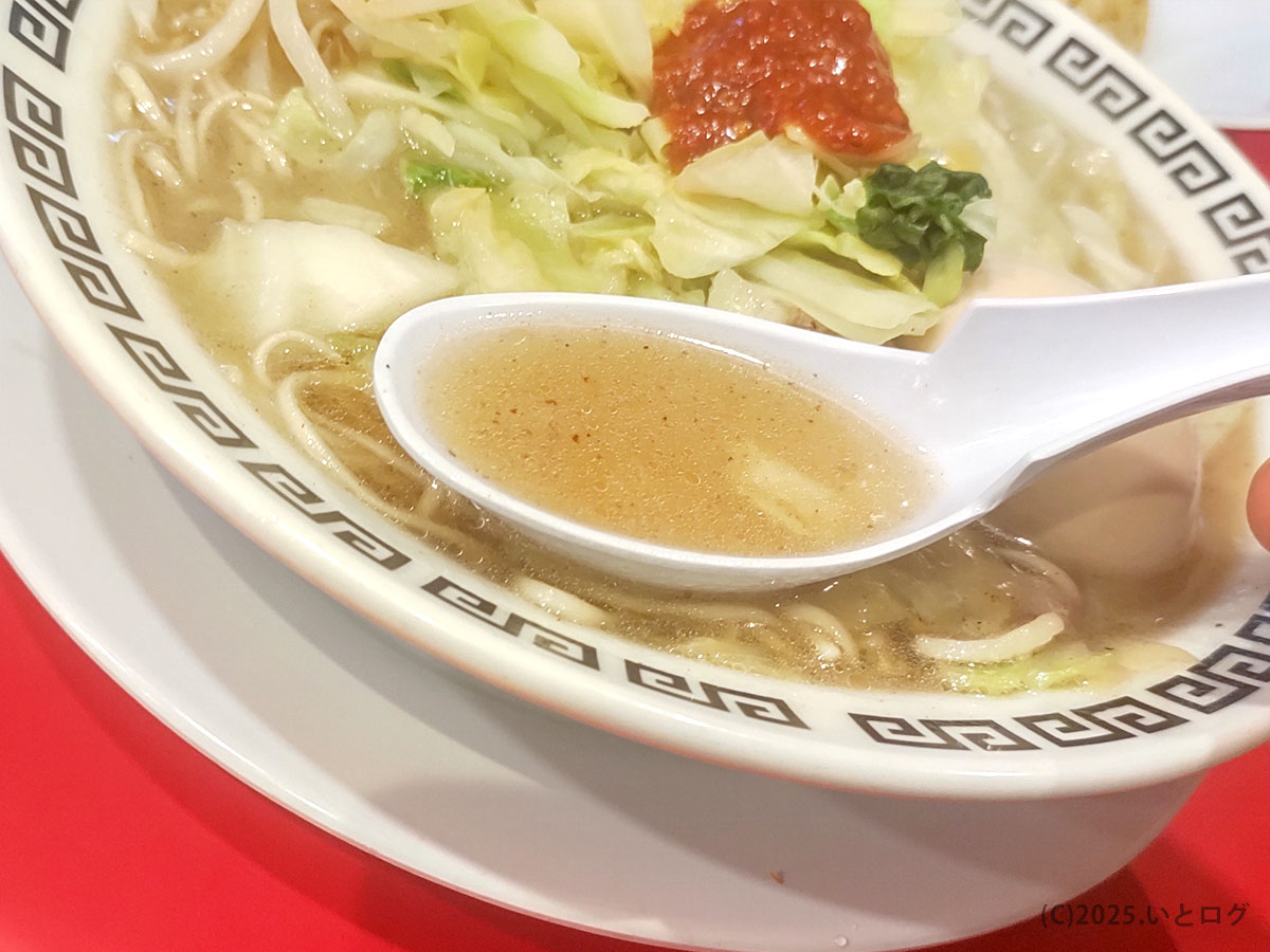透き通る鶏豚スープをレンゲでひとすくい。中央には岐阜タンメン おすすめの辛味ダレが輝く。
