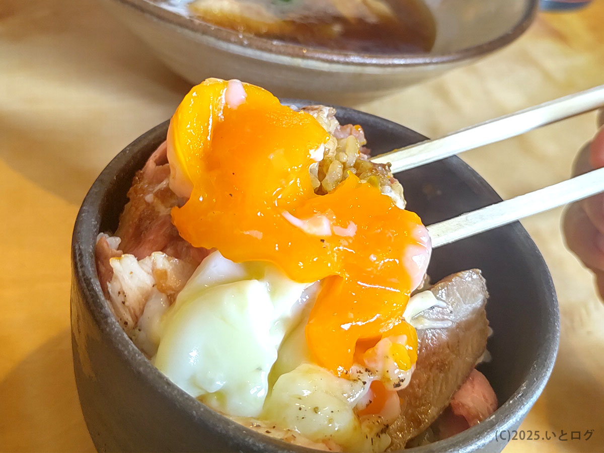 割った温玉の濃い黄身が豚めしに流れ込む瞬間。ラーメン 梅花亭 滋賀 の人気ごはん。