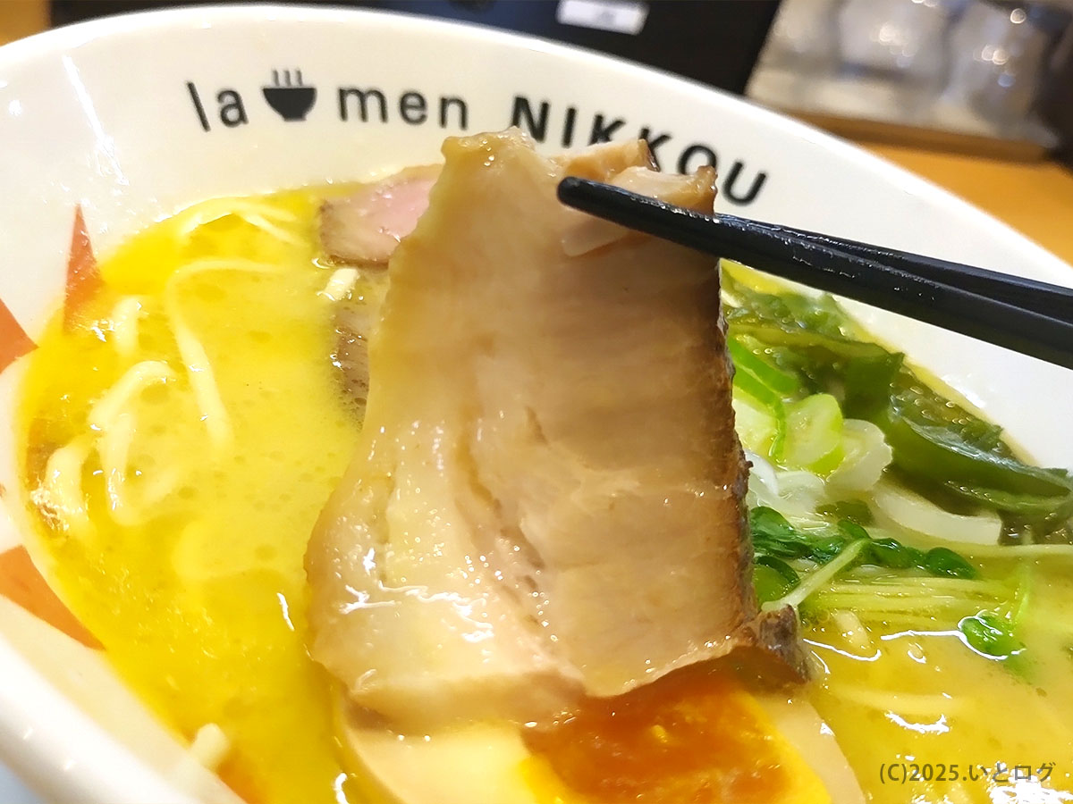 厚切りチャーシューをリフトアップ。“ラーメン に っ こう まずい”の噂を覆すジューシーさが伝わる。