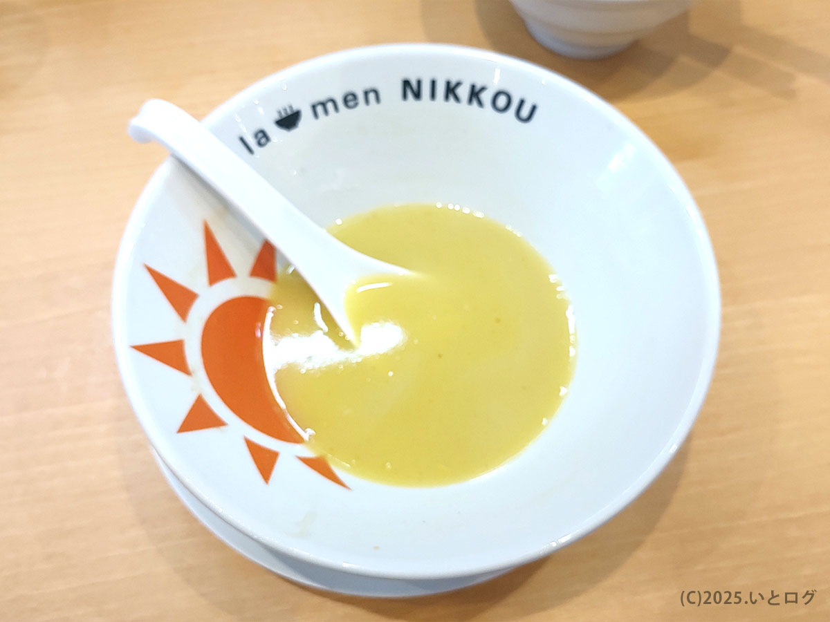 旭日ロゴが映える丼に黄金スープがわずかに残る “あと一口”。ラーメンにっこう 店舗オリジナルの器デザインが印象的。