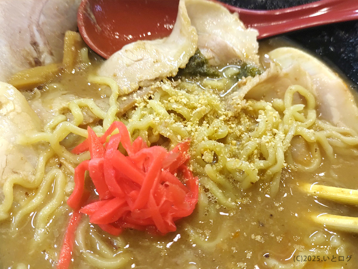 卓上の紅しょうがやすりゴマを加えて味変した豚そば。濃厚スープにさっぱりした酸味と香ばしさが加わり、ラーメン与七のこだわりが感じられる。