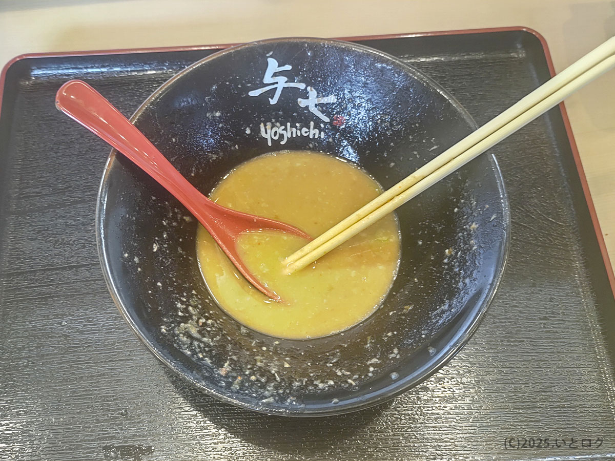 麺を食べ終え、黒い丼の底に「与七 Yoshichi」のロゴが現れる完食寸前の豚そば。濃厚なとんこつ魚介スープが少し残り、満足感が伝わる。