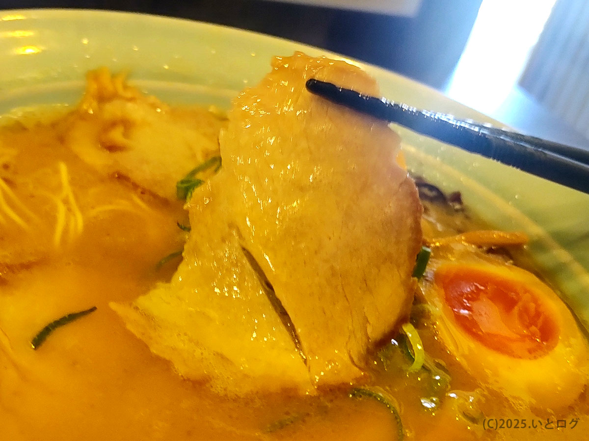 薄切りチャーシューを箸で持ち上げた様子。脂の甘みが広がる真咲雄 ラーメンのチャーシュー
