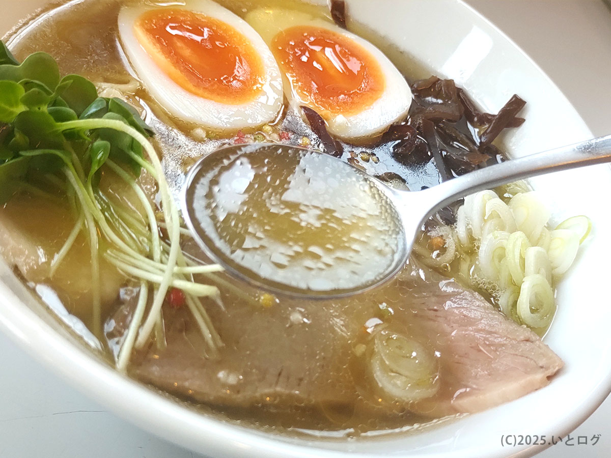 透明感ある淡麗スープをレンゲですくう瞬間。ホットエアー 鳥取市の淡麗鶏らーめんの真髄がここに。