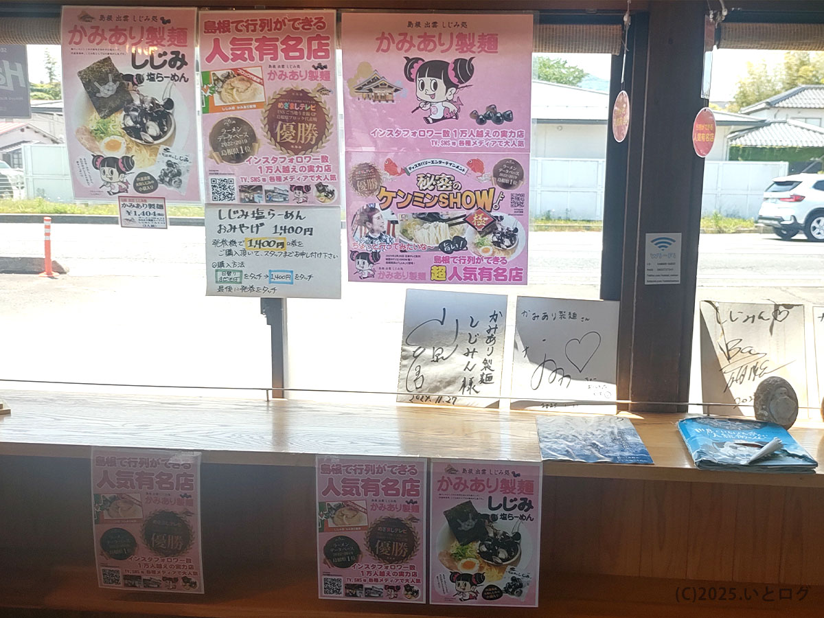 島根県出雲市の人気店 かみあり製麺の店内。しじみラーメンを紹介するポスターや芸能人のサイン色紙が壁いっぱいに飾られている。