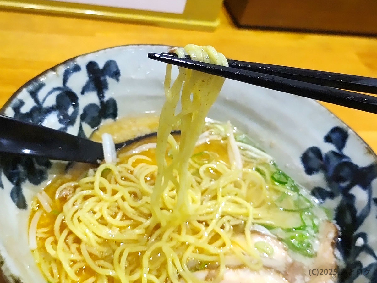 麺屋ひばりのストレート細麺を持ち上げた場面。喉ごしの良さとスープの一体感が伝わる。