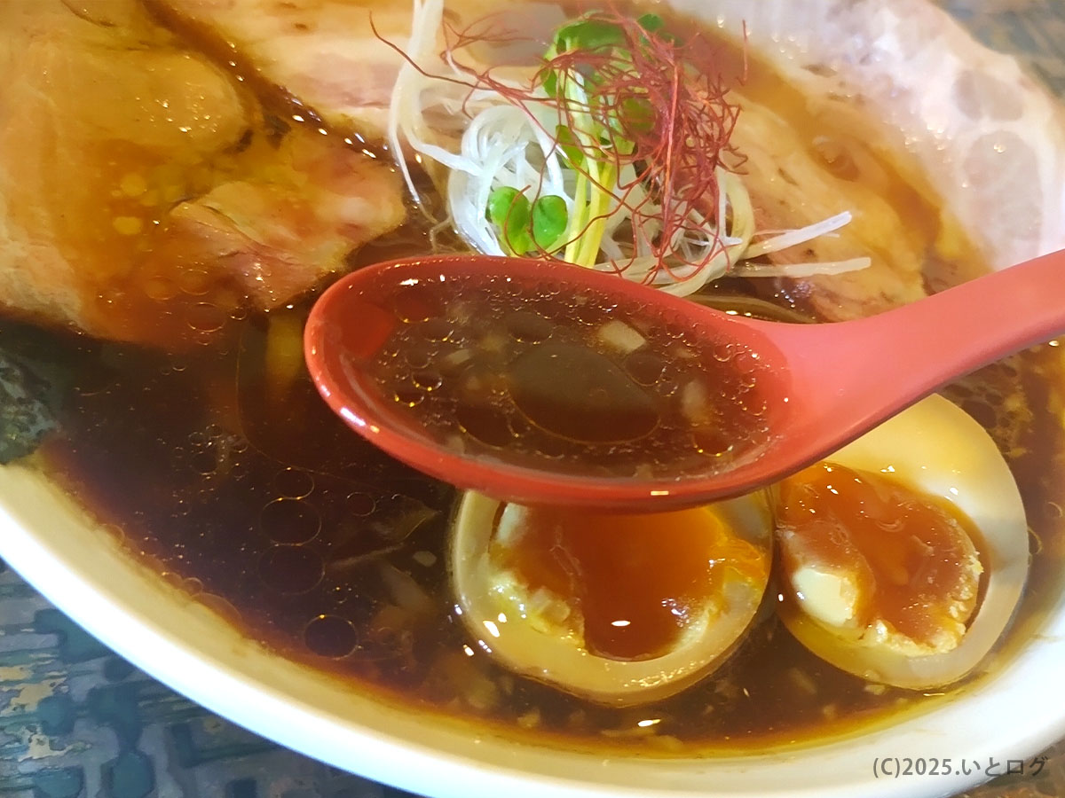 米蔵の醤油ラーメンのスープをレンゲで一口。山口県ラーメンの中でも深みのある味わいで、米蔵の読み方を調べるほど県外から訪れる人も多い。