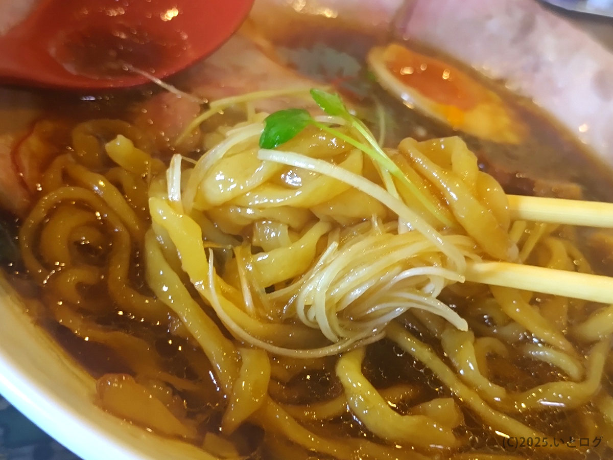 米蔵の麺と白髪ねぎを絡めた一口。山口市のラーメン文化を象徴する一杯で、ランキング常連の人気店。