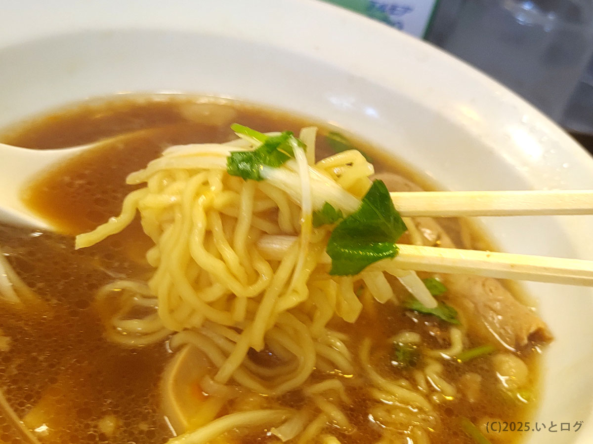 「中華そば 今里」（山口県防府市）の麺と三つ葉を箸で持つシーン。香味野菜の爽やかさがスープの深みを引き立てる。