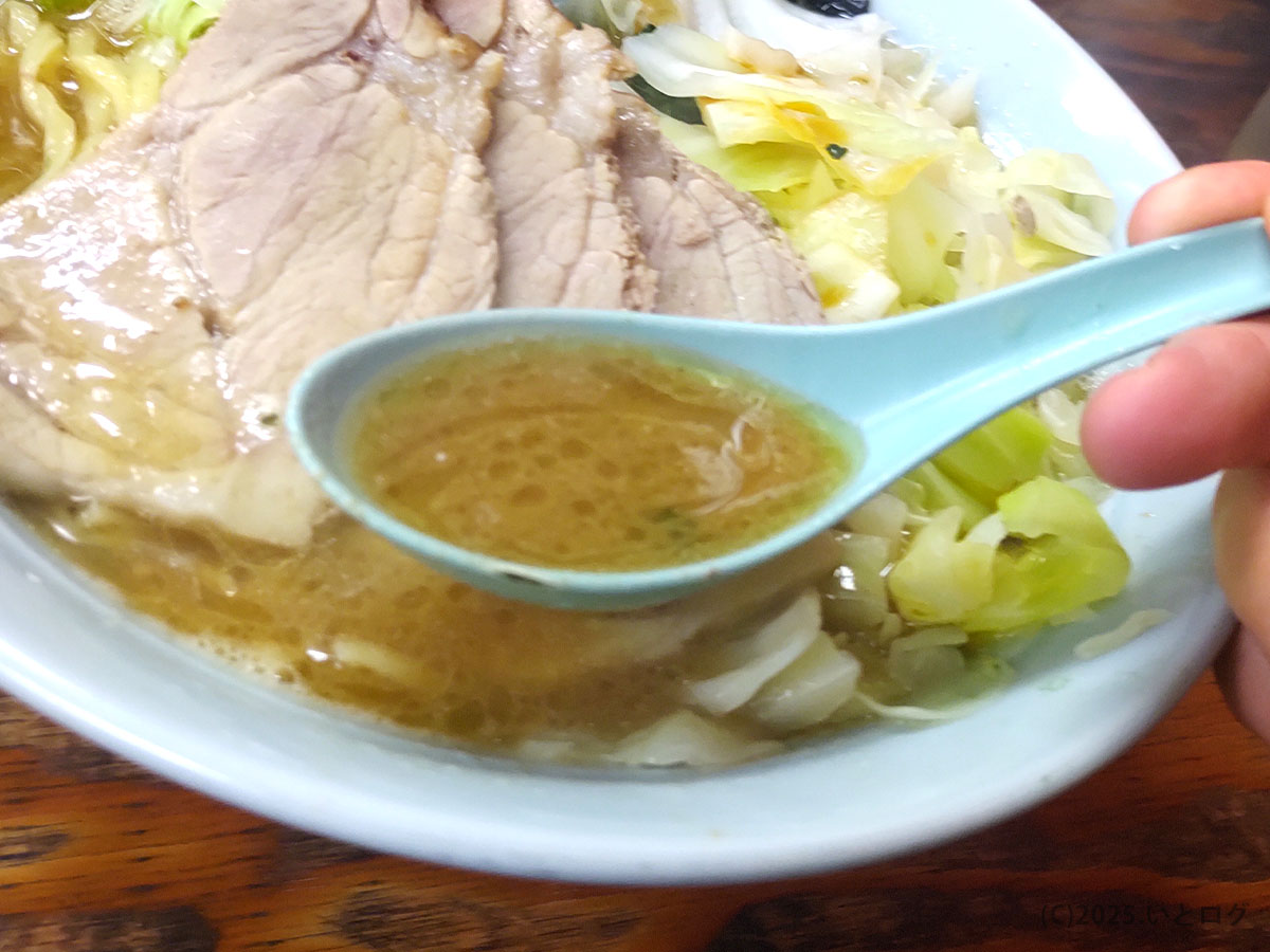 レンゲで掬ったヤスシボーイの豚骨醤油スープ。コク深い旨味が広がり、家系ラーメン下松勢にも人気の一杯。
