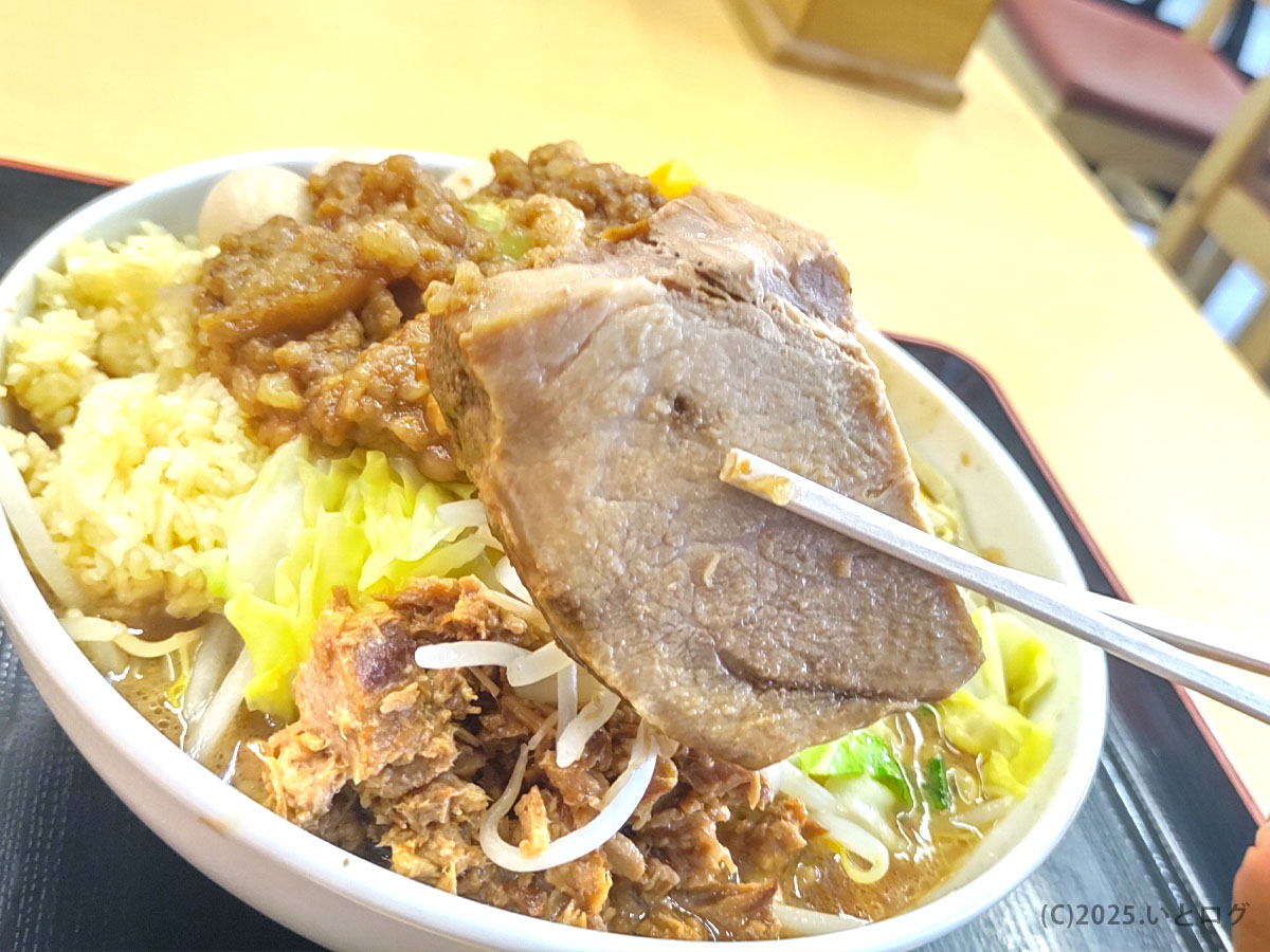 ラーメンオブトゥデイ下松店のチャーシューを箸で持ち上げた様子。分厚くホロホロな豚が特徴。ramen of today系列らしい肉の存在感を堪能できる一枚。