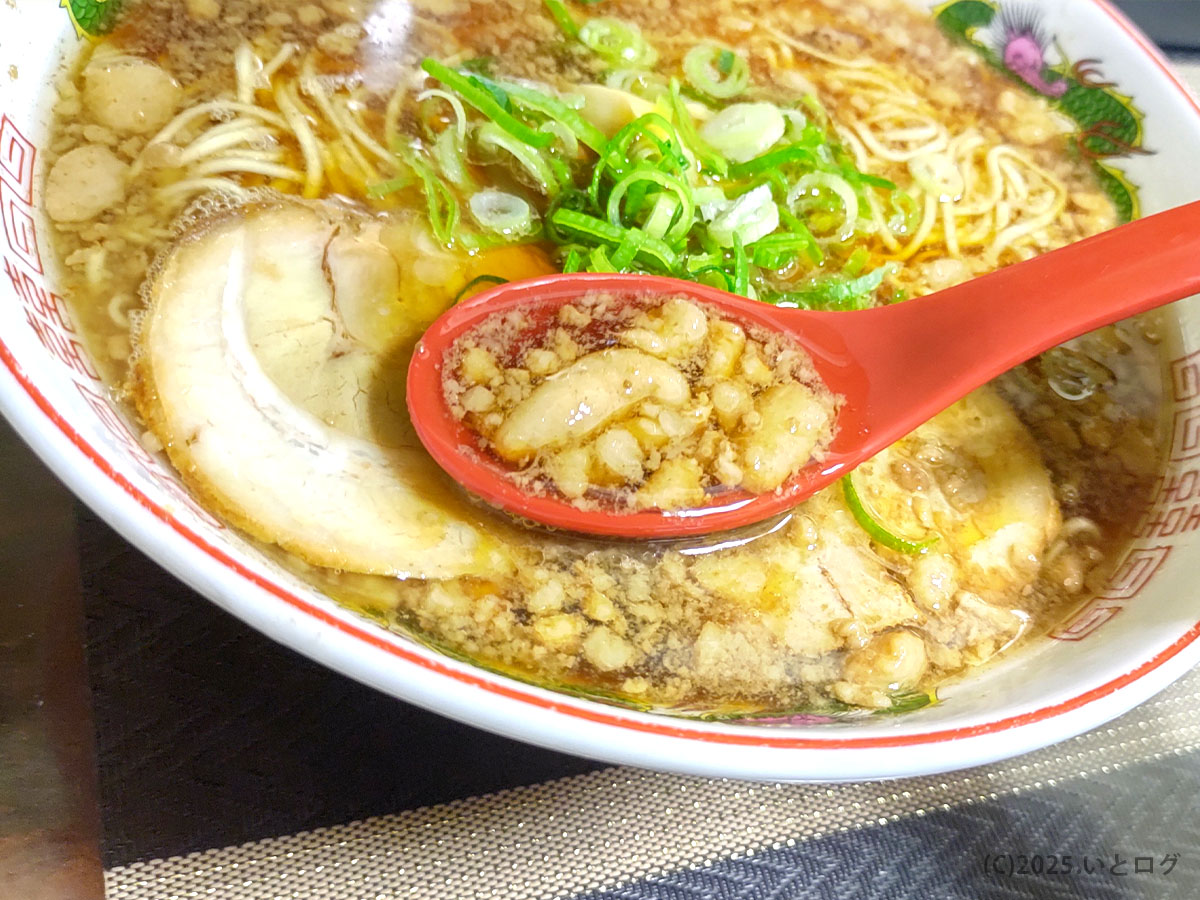尾道ラーメン一丁のレンゲにすくったスープ。背脂と醤油の層がきらめき、熱気と香りが立ちのぼる。尾道ラーメン 一丁 福山の奥深い旨味。