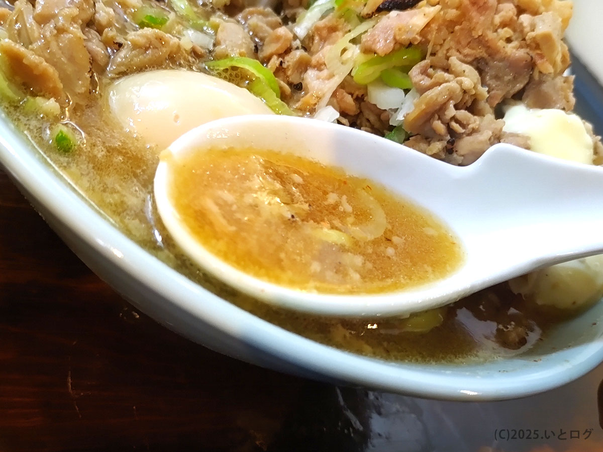 ラーメン紅葉 国分寺のつけ麺スープ。動物系と魚介系が合わさった濃厚な出汁に背脂が浮かび、旨味たっぷり。レンゲですくうと香りが立ち上がる。