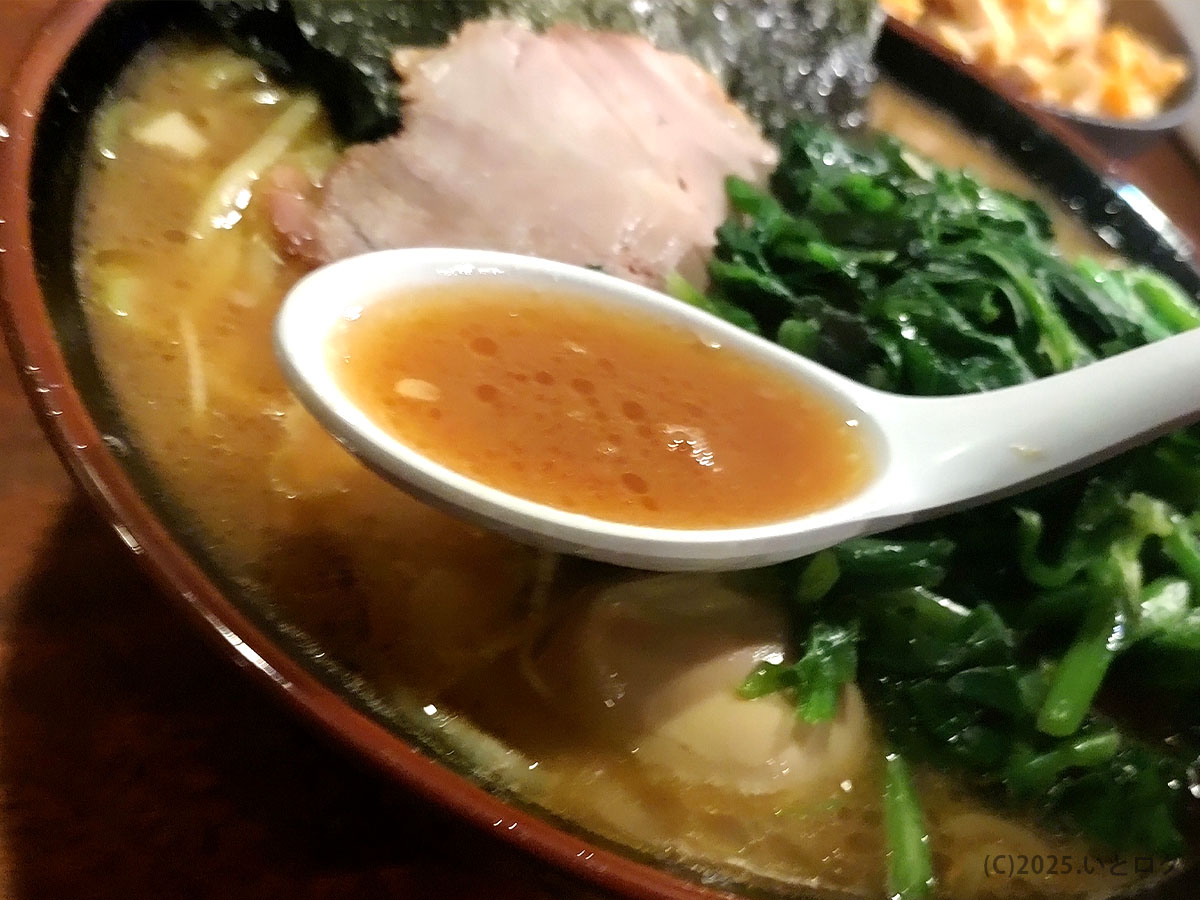 クックらのラーメンのスープ。濃厚でクリーミーな豚骨醤油スープがレンゲに映え、香り立つ一杯。