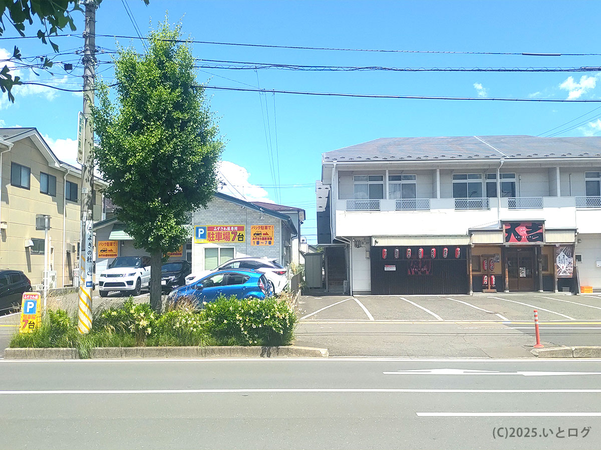 みずさわ屋の店舗外観と駐車場。仙台市青葉区愛子の国道沿いにあり、駐車場は7台分完備。晴れた空の下、地元客で賑わう中華そばの人気店。